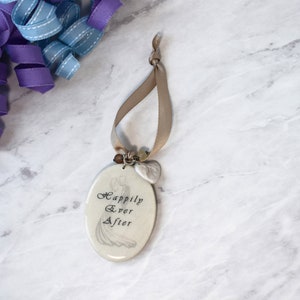 Wedding editable wine tag laying on marble background.  Tag has image of bride and groom and text reading Happily Ever After on the front and an ivory vinyl board on back where personal message may be included.