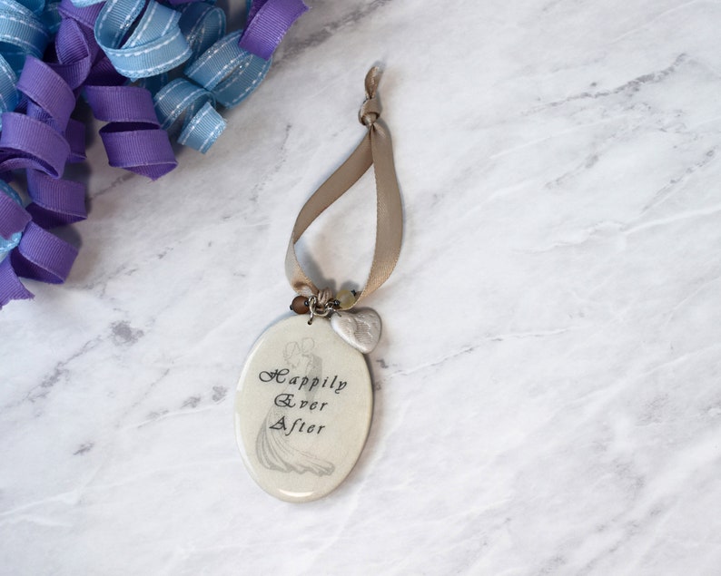 Wedding editable wine tag laying on marble background.  Tag has image of bride and groom and text reading Happily Ever After on the front and an ivory vinyl board on back where personal message may be included.