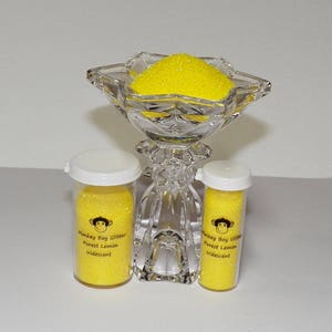 May include: Two small jars of yellow iridescent glitter labeled "Monkey Boy Glitter Purest Lemon Iridescent" and a larger glass bowl filled with the same glitter.