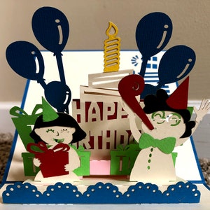 Birthday Card: Two Children with a Candle-Topped Cake and Balloons