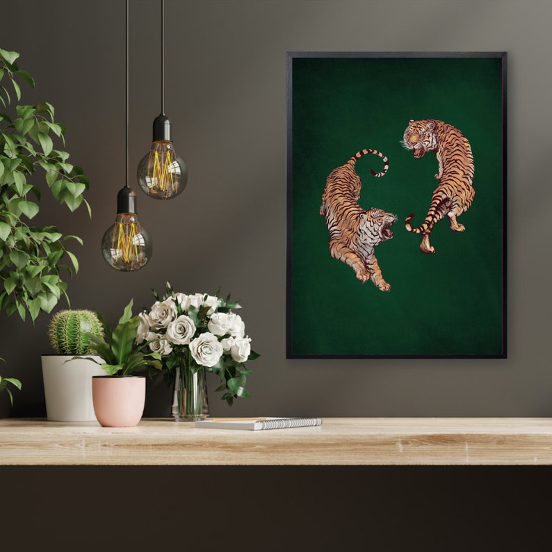 Op de afbeelding: Een ingelijste print van twee tijgers op een groene achtergrond. De tijgers kijken elkaar aan, een ligt en de ander staat.