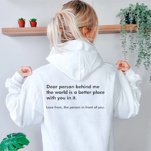 May include: White hoodie with a black text message on the back that reads "Dear person behind me the world is a better place with you in it. Love from, the person in front of you."