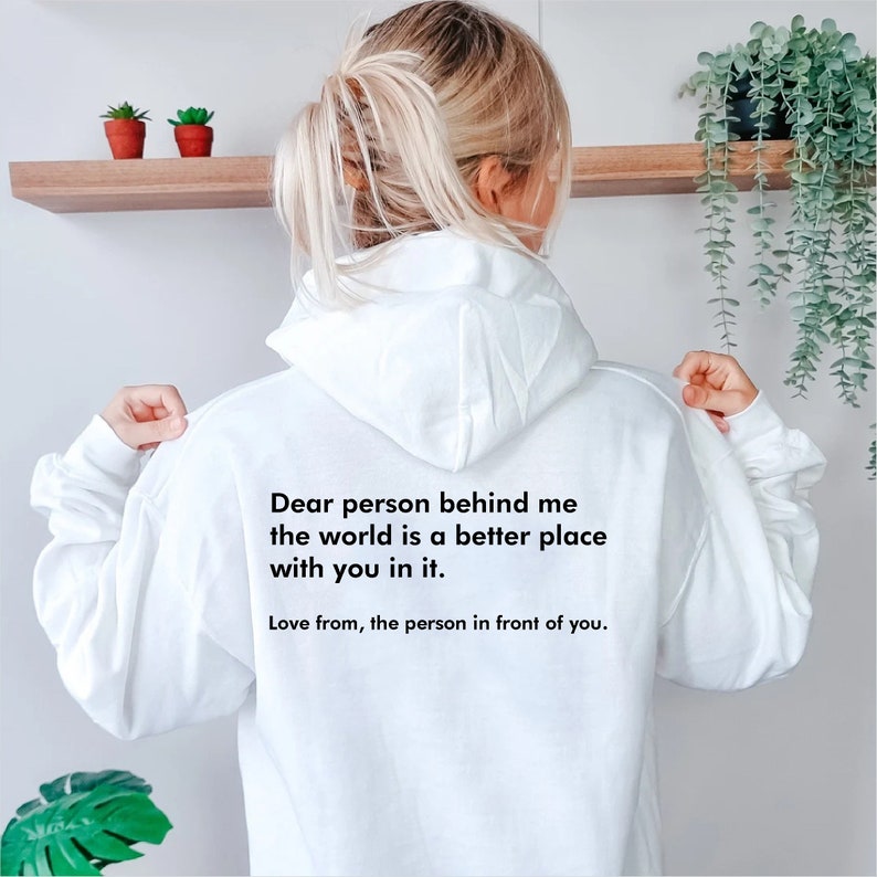 May include: White hoodie with a black text message on the back that reads "Dear person behind me the world is a better place with you in it. Love from, the person in front of you."