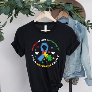 Autism är inte funktionsnedsättning T-shirt med band – Different Ability Jigsaw Autism Awareness Tee