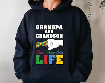 May include: A navy blue hoodie with the text "GRANDPA AND GRANDSON" in white. Below, a graphic shows a hand holding a puzzle piece with the words "Best Friend For LIFE" in colorful letters. The hoodie is a casual garment.