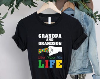 May include: Black t-shirt with the text "GRANDPA AND GRANDSON" in white. Below the text is a graphic of a puzzle piece and a fist bump. The words "Best Friend For LIFE" are in colorful letters.