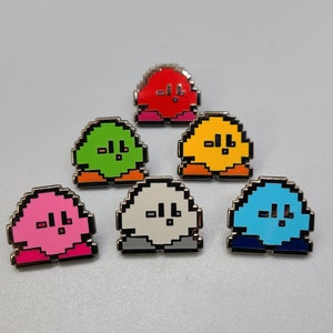 May include: Six enamel pins featuring a pixelated character with different colored bodies. The characters are red, green, yellow, white, blue, and pink.