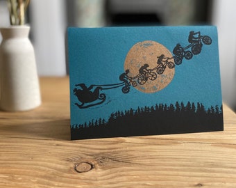 Merry bikemas single Christmas card | Bikes pulling Santa's sleigh | Moon | Bike lovers | Hand printed |  lino print gold moon on teal card