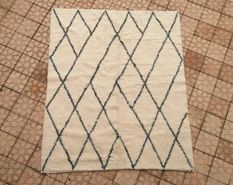 May include: A white rug with a black diamond pattern. The rug has a soft, fluffy texture.