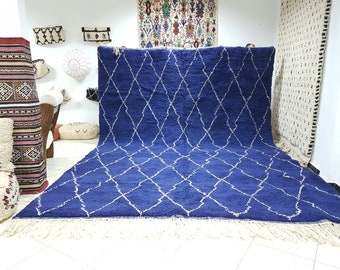 Puede incluir: Una alfombra marroquí azul y blanca con un patrón de diamantes. La alfombra tiene un borde de flecos y está hecha de lana.