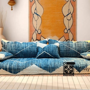 May include: A blue and white floor cushion with a geometric pattern. The cushion is made of woven fabric and has a comfortable, relaxed look. It is perfect for a living room or bedroom.