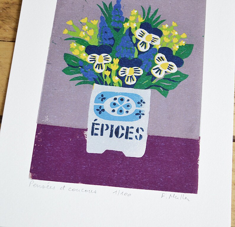 May include: A colorful floral print featuring a bouquet of blue, yellow, and white flowers in a white vase with the word "&Eacute;PICES" printed on it. The print has a purple and lavender background. The print is on a white background.