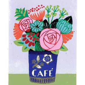 Peut inclure: Un bouquet de fleurs coloré dans un vase en céramique bleu avec le mot "CAFÉ" écrit en blanc sur le devant. Le vase a une bordure dorée autour du haut.