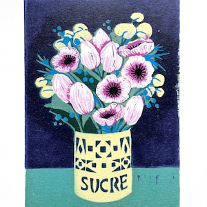 Peut inclure: Une impression florale colorée représentant un bouquet de tulipes roses et d'anémones dans un vase jaune avec le mot "SUCRE". Le vase a un motif géométrique. Le fond est bleu foncé et turquoise.