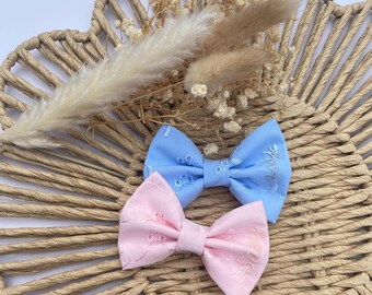 Pinza para el cabello personalizada con lazo de bordado inglés en rosa o azul.