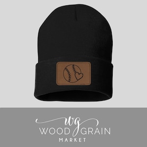 May include: Black beanie with a brown leather patch featuring a baseball and heart design. The patch has the text "wg WOOD GRAIN MARKET" on it.