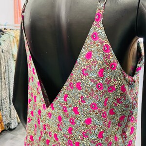 May include: A sleeveless dress with a V-neckline and a floral print. The dress is made of a lightweight fabric and has a relaxed fit.