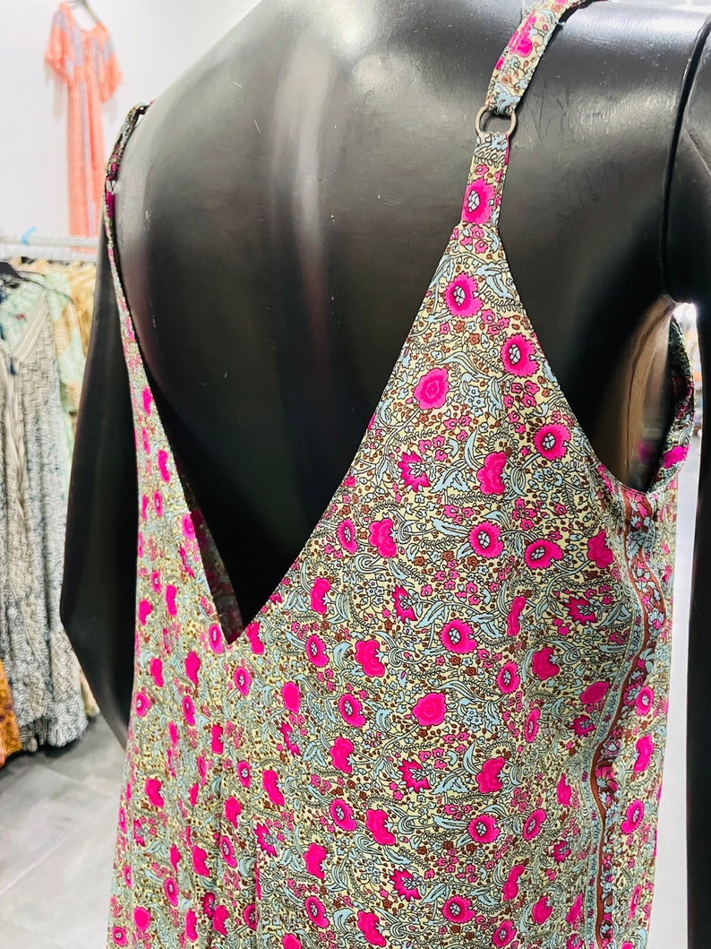 May include: A sleeveless dress with a V-neckline and a floral print. The dress is made of a lightweight fabric and has a relaxed fit.
