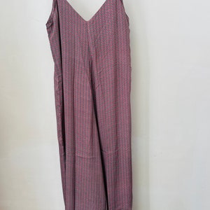 May include: A long, sleeveless, V-neck jumpsuit with a pink and gray geometric pattern.
