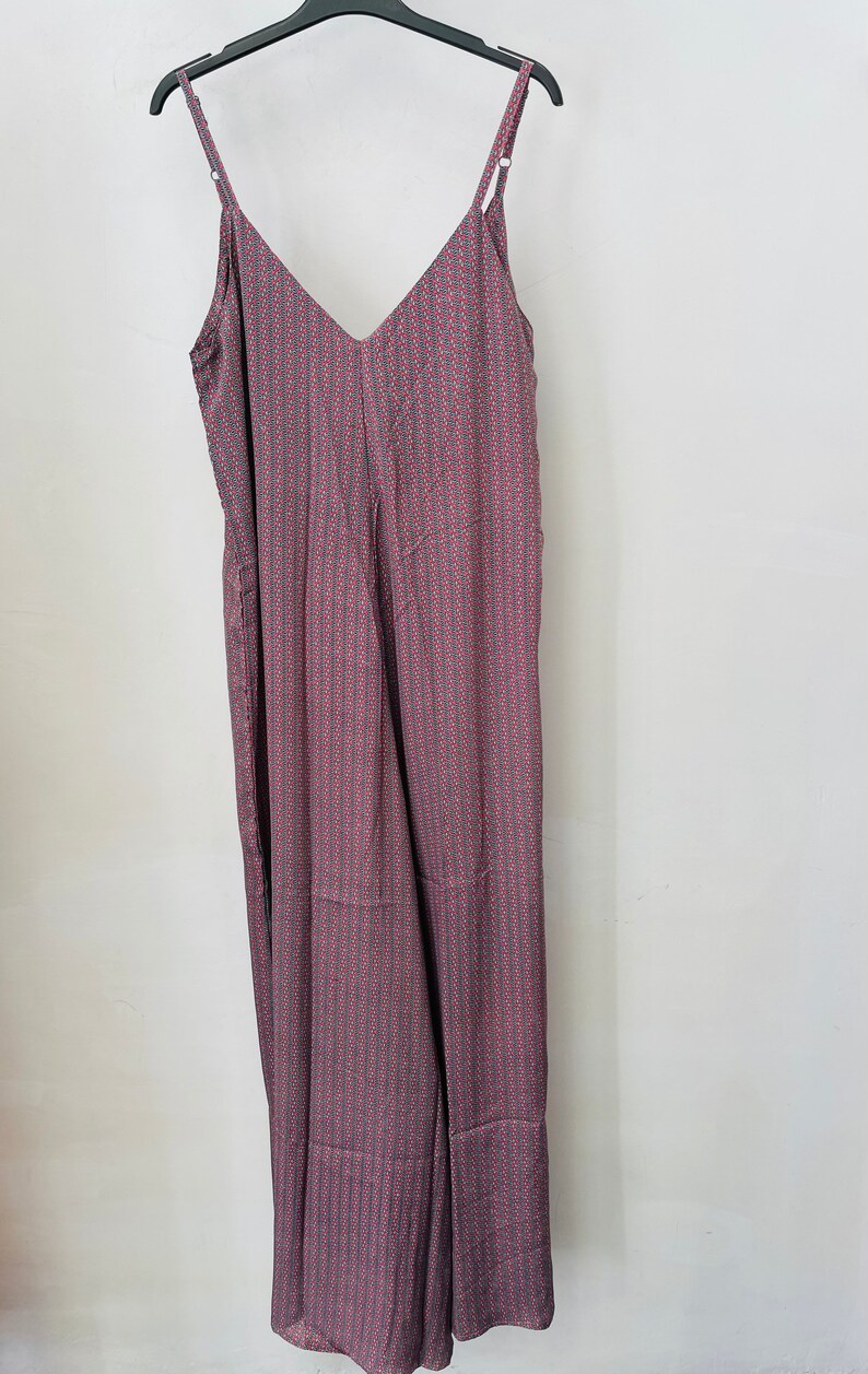 May include: A long, sleeveless, V-neck jumpsuit with a pink and gray geometric pattern.