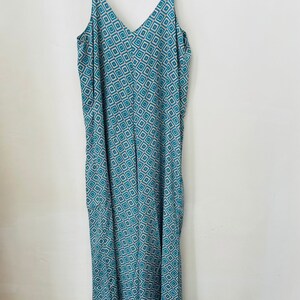 May include: A long, sleeveless, blue and white patterned jumpsuit with a V-neckline.