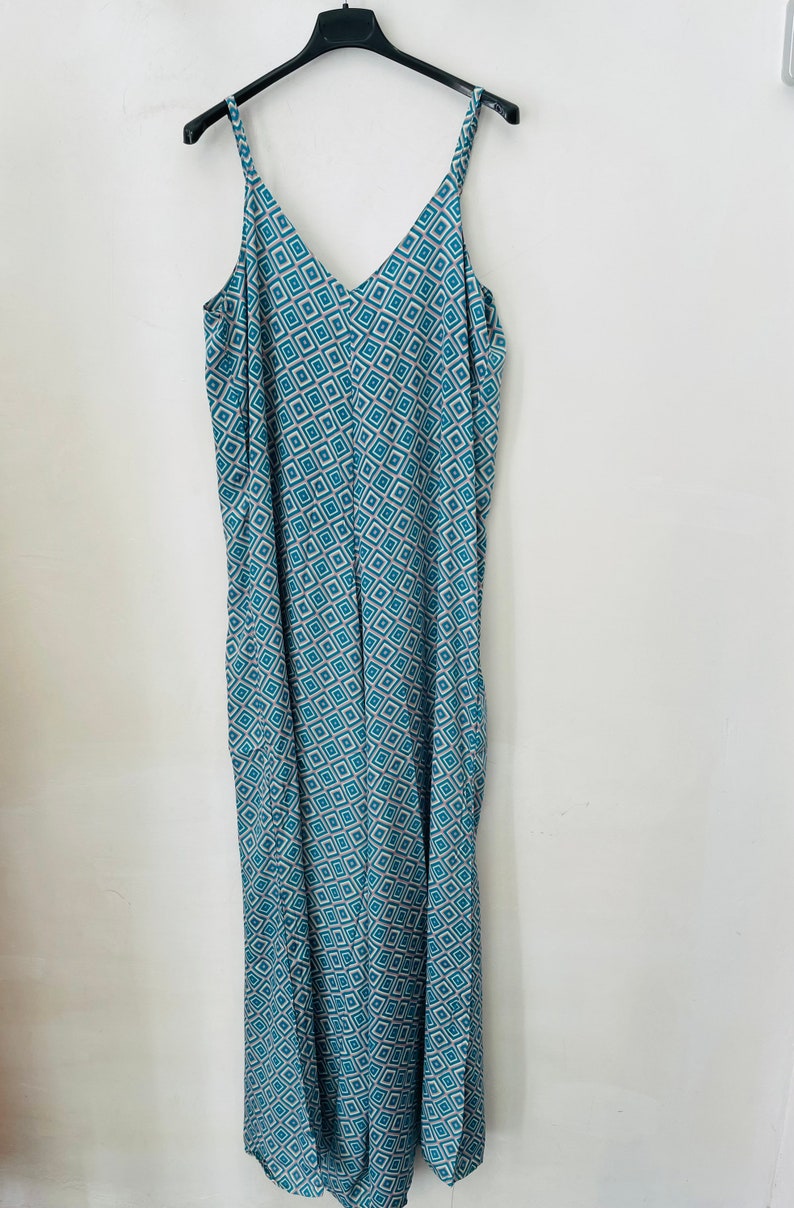 May include: A long, sleeveless, blue and white patterned jumpsuit with a V-neckline.