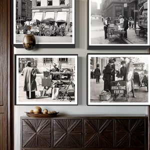 May include: A set of four black and white framed photographs depicting street scenes from the early 20th century.  The images show various street vendors selling goods from carts, including one labeled 'A Noon Time Friend'.  The photos are displayed on a dark brown wooden sideboard with carved details, accompanied by three bowls. The overall theme is vintage street scenes and antique home decor.