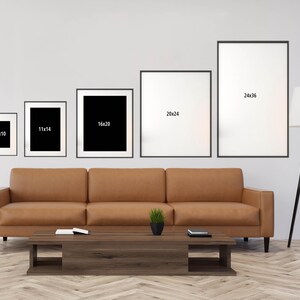 a living room with a couch, coffee table and three pictures on the wall