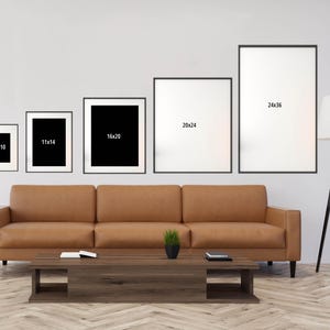 a living room with a couch, coffee table and three pictures on the wall
