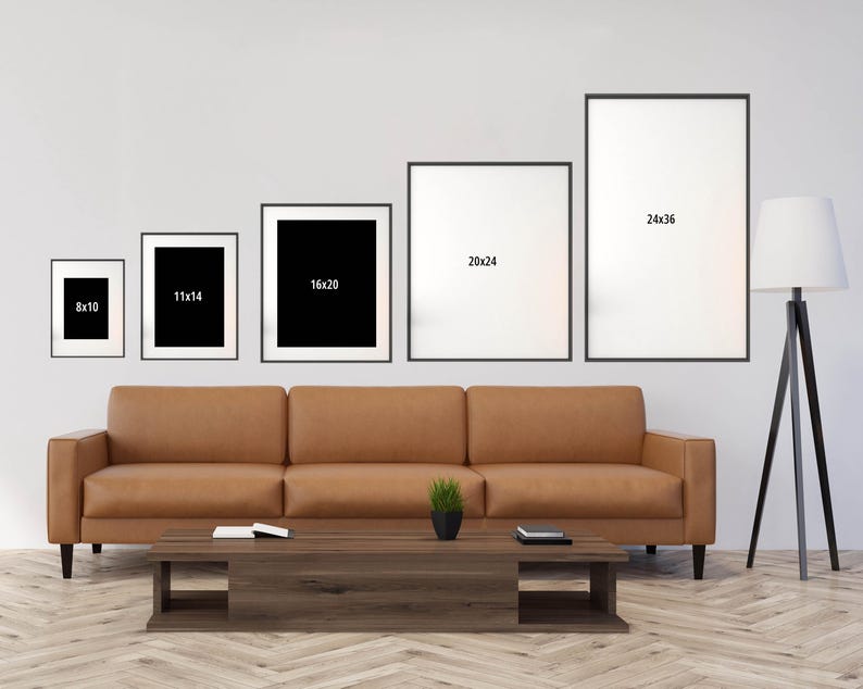 a living room with a couch, coffee table and three pictures on the wall