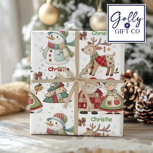 May include: A wrapped gift with a festive Christmas theme. The wrapping paper features illustrations of snowmen, reindeer, Santa Claus, and Christmas trees. The gift is tied with a gold ribbon and the name "Christie" is printed on the wrapping paper.
