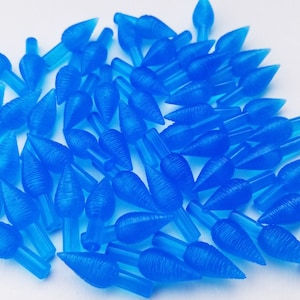 May include: A pile of blue plastic Christmas light bulbs with a pointed tip. The bulbs have a textured surface and are designed to resemble a flame.