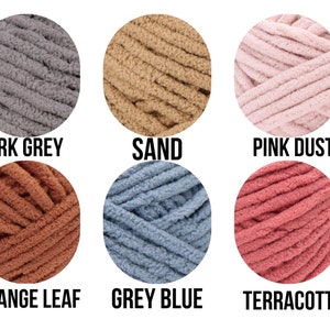 Puede incluir: Diez ovillos de lana en varios colores, incluyendo carmes&iacute;, gris oscuro, arena, polvo rosa, azul helado, merlot, hoja naranja, azul gris, terracota y verde brumoso.