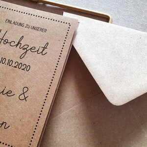 May include: A brown paper wedding invitation with a dotted border. The invitation reads "Einladung zu unserer Hochzeit am 10.10.2020 Marie & Anton".