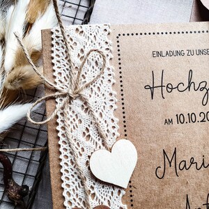May include: A rustic brown wedding invitation with a lace trim and twine bow. The invitation reads "Einladung zu unserer Hochzeit am 10.10.2020 Marie & Anton".