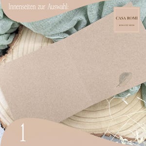 May include: A blank, brown card with a leaf design and the text "CASA ROMI ROMANTIC MINDS" in the top right corner. The card is on a wooden surface with a green fabric in the background. The number "1" is in the bottom left corner.