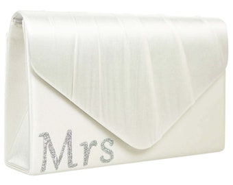 Pode incluir: Clutch de cetim branco com um design de "Mrs." em glitter prateado.