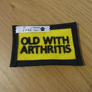 Pu&ograve; includere: Toppa per pettorina per cani in feltro giallo con testo nero che recita "Old with Arthritis" e un nastro bianco con testo nero che recita "Tori Harness Signs" e un'impronta di zampa.
