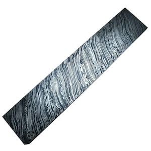 May include: A long, thin piece of black and white patterned steel. The steel has a wavy, flowing pattern.