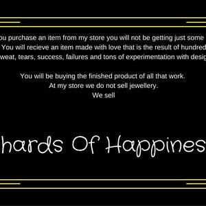 May include: Black background with a yellow decorative border and text. The text reads "When you purchase an item...Shards Of Happiness." The text describes the product as being made with love and the result of hours of work.