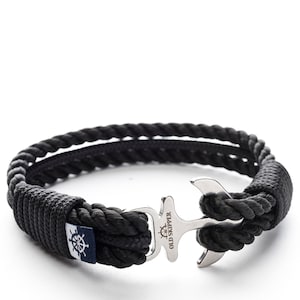 May include: Black rope bracelet with a silver anchor clasp. The anchor has the words "Old Skipper" engraved on it.