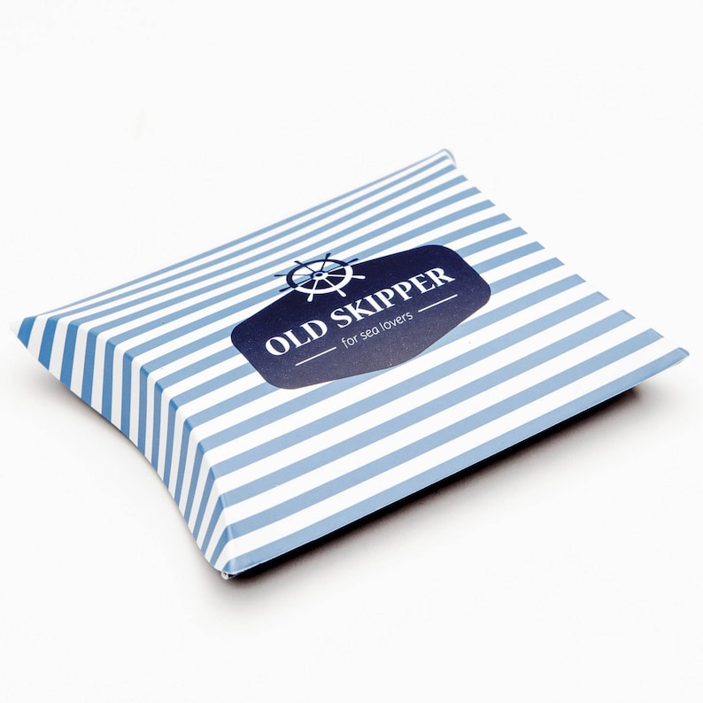 May include: A blue and white striped pillow box with a logo that says "OLD SKIPPER - for sea lovers" and a nautical wheel graphic.