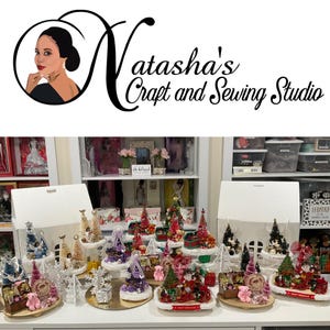 May include: A collection of miniature Christmas trees decorated with various ornaments, ribbons, and figurines. The trees are arranged on tiered stands, creating a festive display. The image includes the text "Natasha's Craft and Sewing Studio".