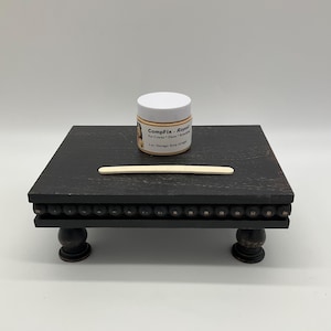 May include: A black wooden riser with decorative beaded trim and turned legs. A small jar labeled "CompFix - Repair" and a wooden applicator stick are on the riser. The jar contains 2 oz of product.