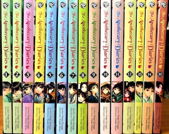 Puede incluir: Una colección de quince volúmenes del manga "The Apothecary Diaries". Cada libro tiene un lomo de color diferente. Las portadas muestran ilustraciones de personajes, el título de la serie y los números de volumen.