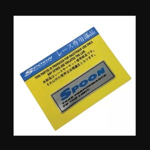 May include: A silver metal sticker with blue lettering that reads "SPOON TAKE PERFORMANCE TO THE LIMIT." The sticker is on a yellow background with Japanese text that reads "THIS PART(S) IS PRODUCED FOR RACETRACK USE ONLY. ANY OTHER USE VIOLATES THE LAW. 本部品はレースサーキット使用部品です。 それ以外の使用は法規違反となります。"