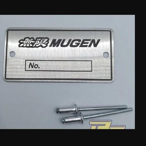 Könnte beinhalten: Eine silberne Metallplatte mit dem Text "無限 MUGEN" und "No." darauf gedruckt. Die Platte hat zwei kleine Löcher oben und unten. Zwei silberne Metallschrauben sind im Lieferumfang enthalten.