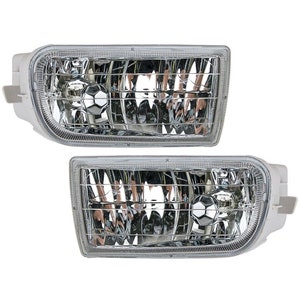 May include: A pair of clear plastic fog lights with a chrome trim. The lights have a rectangular shape and a grid pattern on the front.