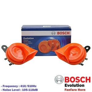 Puede incluir: Dos bocinas Bosch Evolution Fanfare naranjas con soportes de montaje se muestran frente a una caja azul y blanca. La caja tiene el logotipo de Bosch y las palabras "Evolution" y "Fanfare Horn". Las bocinas tienen una frecuencia de 410/510 Hz y un nivel de ruido de 105-118 dB.