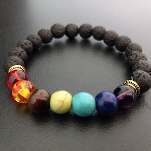 May include: A black lava rock bracelet with seven chakra beads. The beads are red, orange, yellow, green, turquoise, blue, and purple.